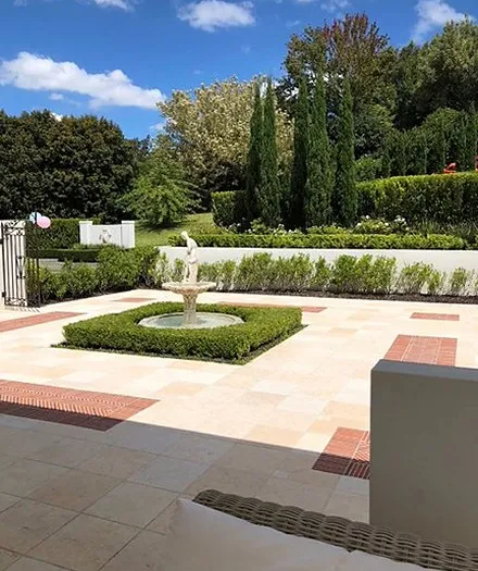 A fountain courtyard framed by clipped hedging