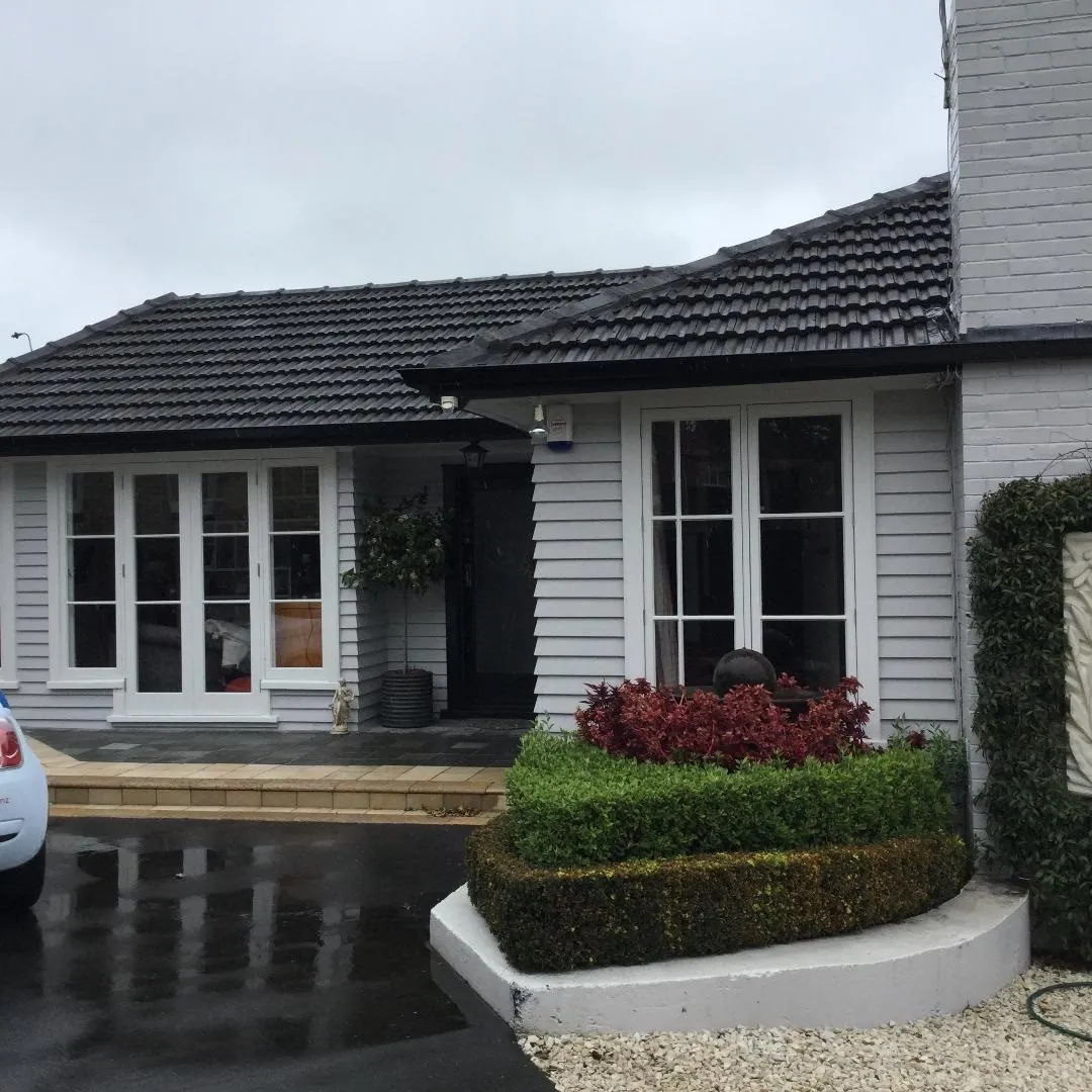 A weatherboard home with clipped hedging and a tidy frontage